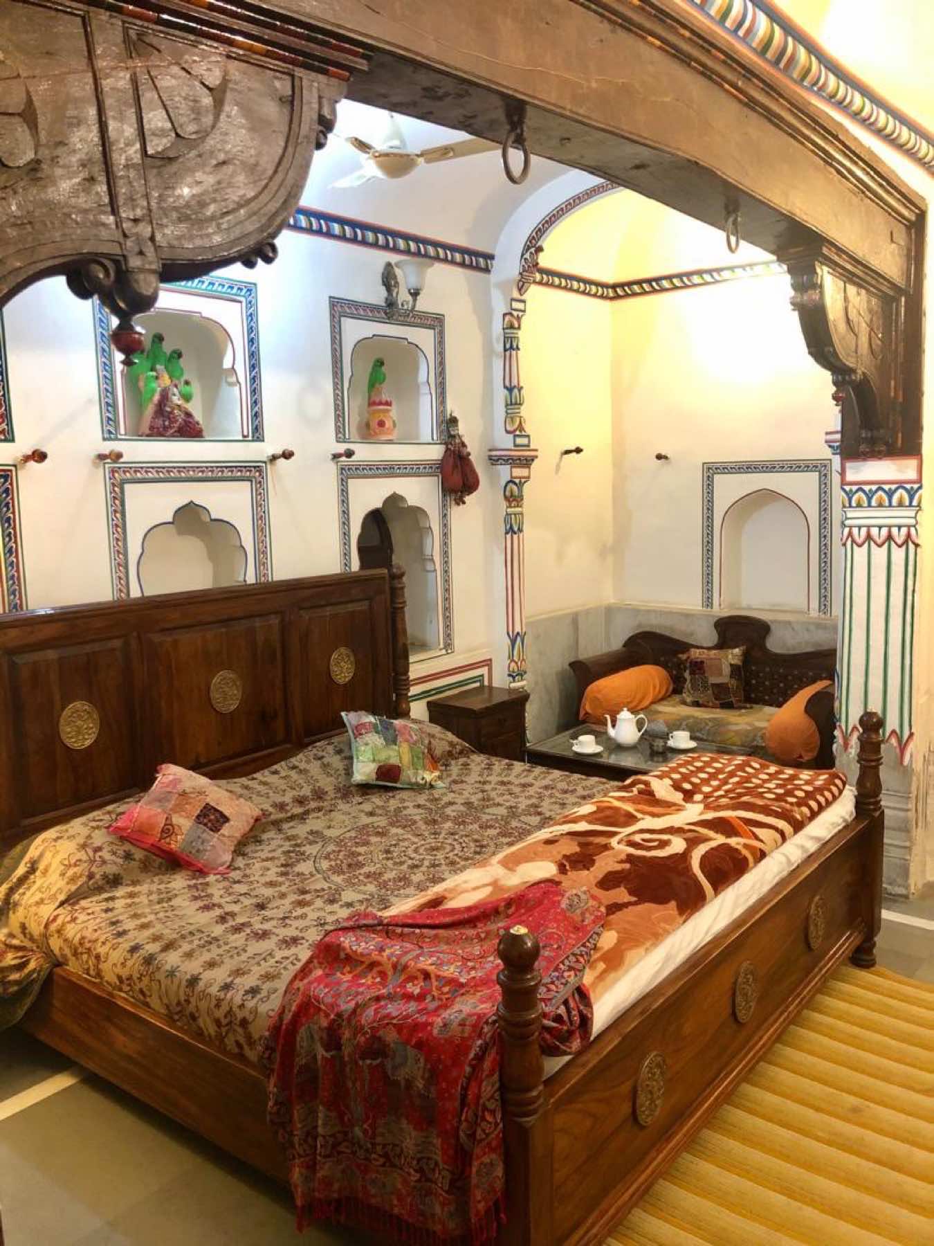 Carved four-poster bed inside a heritage painted haveli in Mandawa